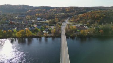Güneşli bir sonbahar gününde, güzel, pürüzsüz, yeşil bir göl manzarası. Ormanlar ve evlerle çevrili zümrüt göl manzaralı kuşların bakış açısı