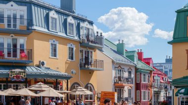 Whistler, Kanada 'da renkli dükkanları ve restoranları olan canlı bir köy sahnesi. Turistler ve yerliler güneşli sokakların keyfini çıkarırken, bu manzaralı yerin canlı atmosferini kucaklıyorlar..