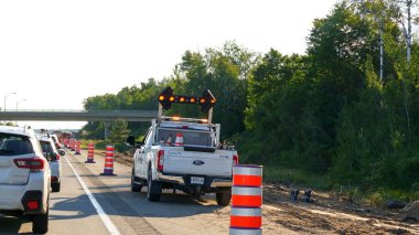 Mont-Tremblant QC Canada - 22.09.2024: Yolun kenarında turuncu trafik konilerinin yanındaki beyaz bir kamyonun arkasında modern ok işareti.