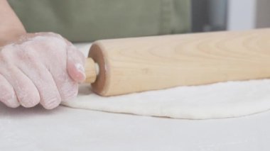 Pizza hazırlama - kadınların elleri un kaplı bir masada hamur yoğurur. Ev yapımı pizza.