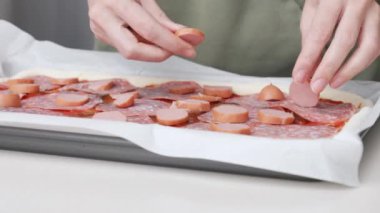 Tahta masa üzerinde servis edilen peynirli ve sosisli ev yapımı kare pizza tam peynirli organik pizza sağlıklı pizza..