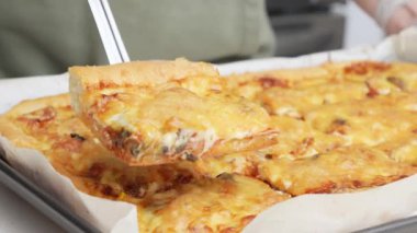 Tahta masa üzerinde servis edilen peynirli ve sosisli ev yapımı kare pizza tam peynirli organik pizza sağlıklı pizza..