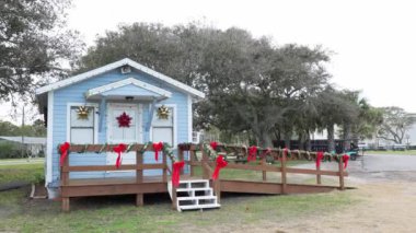 Kenly, NC USA 03.15.2024: Yard 'da Şenlikli Noel Süslemeleri ve Palmiye Ağaçlarıyla Küçük Mavi Kulübe.