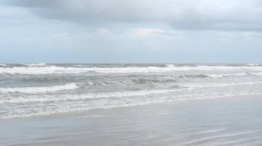 Sisli bir günde Jacksonville Florida Plajı. Kışın doğu kıyısında beyaz kumsalda. Okyanusta dalgalar. Florida, ABD