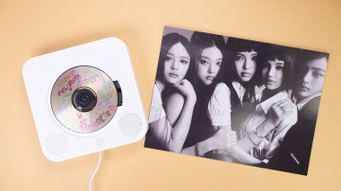 K-pop group NewJeans Album photobook on yellow. Music CD player. South Korean girl group NewJeans. Space for text. Gatineau, QC Canada - March 16 2024 clipart