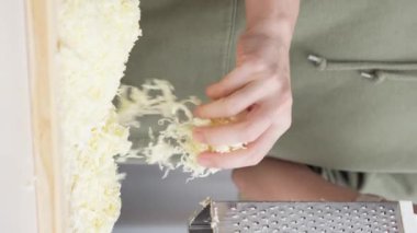 Izgara peynir aşçının elinden düşer. Pizza için rendelenmiş peynir.