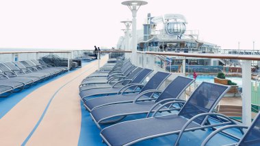 Lüks bir yolcu gemisinin güvertesinde düzgün sıralarda dizilmiş mavi güverte koltuklarının huzurlu manzarası. New York NY ABD - 09.02.2024.