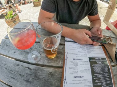 Ottawa, ON, Kanada - 09.05.2021: İşten sonra restoranın verandasında yemek sipariş eden genç arkadaşların bakış açısı - mutlu insanların birlikte vakit geçirdiği ve kokteyl içtiği arkadaşlık kavramı.