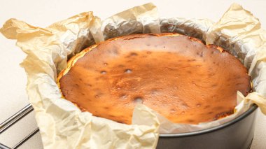 Beyaz arka planda çatlakları olan ev yapımı lezzetli fırınlanmış cheesecake 'in göz kamaştırıcı üst görüntüsü.