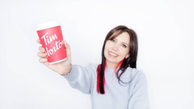 Uzun Koyu Saçlı Neşeli Genç Kadın Tim Hortons 'un Sıcak Kahvesini İçen Mavi Süveter - Kanada' da Ottawa