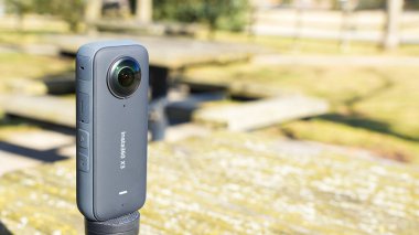 Syracuse NY USA - 08.02.2024: Insta360 Kameralı Siyah Üçayak Bir Sahne Açık Park Ayarında Bir Masada.