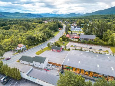 Bu çarpıcı hava manzarası görkemli dağların arasına yerleştirilmiş büyüleyici bir New England kasabasını yakalıyor. Bereketli yeşil ormanlar, açık mavi gökyüzü ve kabarık bulutlar güzelliği artırıyor..