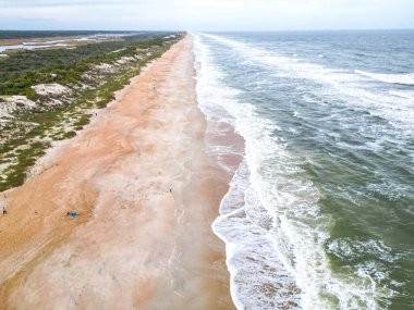 Plajda berrak turkuaz sularla buluşan yumuşak, altın kum bulunuyor. Hafif dalgalar kıyıya vurur, sakin bir atmosfer yaratır rahatlama ve keyif için mükemmel..