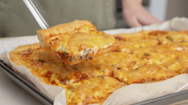 Tahta masa üzerinde servis edilen peynirli ve sosisli ev yapımı kare pizza tam peynirli organik pizza sağlıklı pizza..