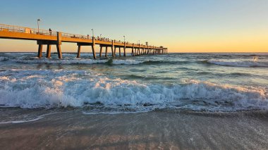 Fort Walton Beach, FL USA - 12.29.2024: Sunset Waves 'deki Sahile Çarpan Sahne Okyanusu İskelesi, Altın Işık ve Huzur Atmosferi.