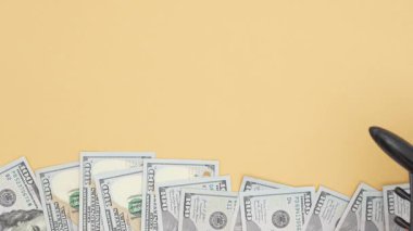 Sarı arka planda bir yığın Amerikan doları. Uçak arka planda hareket ediyor. Seyahat masrafları, finans, zenginlik.