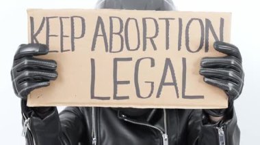 Siyah deri ceket ve eldiven giyen bir insanın elinde 