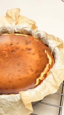 Beyaz arka planda çatlakları olan ev yapımı lezzetli fırınlanmış cheesecake 'in göz kamaştırıcı üst görüntüsü.
