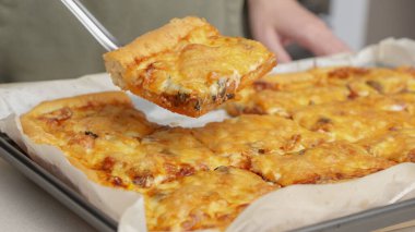 Tahta masa üzerinde servis edilen peynirli ve sosisli ev yapımı kare pizza tam peynirli organik pizza sağlıklı pizza..