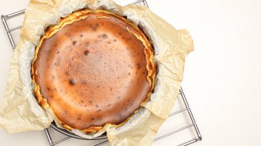 Beyaz arka planda çatlakları olan ev yapımı lezzetli fırınlanmış cheesecake 'in göz kamaştırıcı üst görüntüsü.