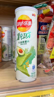 Ottawa, On Canada - 03.06.2025: Market rafında sergilenen silindirik bir pakette avokado aromalı patates cipsi, renkli markalaştırma ve çekici abur cubur sunumu