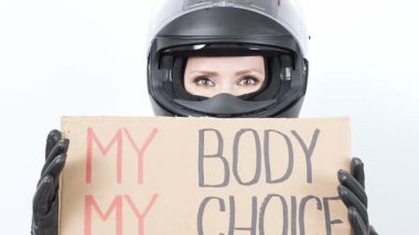 Siyah motosiklet kaskı ve eldiven takan birinin elinde 