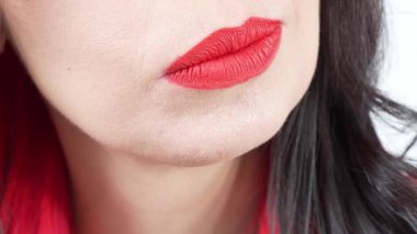 Mutlu bir gülümseme, yakın plan kırmızı rujlu dudaklar. Beyaz dişlerini gösteren kırmızı dudaklı beyaz bir kız. İsimsiz kadın stüdyosu hala yavaş çekim yapıyor.
