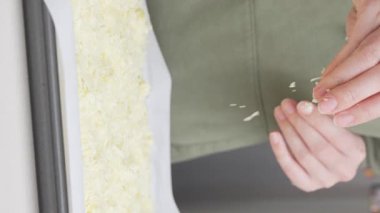 Izgara peynir, aşçının elinden pizzanın üzerine düşer. Ev yapımı pizza. Pizza için rendelenmiş peynir.