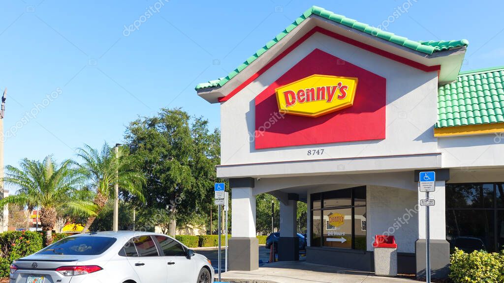 Orlando FL, United States - December 31, 2024: Exterior view of Denny's restaurant featuring logo, palm trees, and bright blue sky creating inviting atmosphere