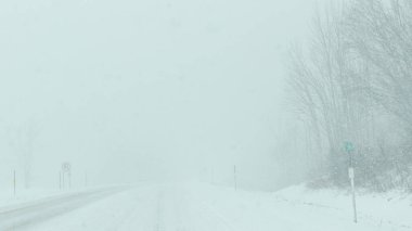 Syracuse NY, ABD - 3 Ocak 2025: Şiddetli kar yağışı ve kış hava koşulları altında araçlar karlı bir yolda ilerliyor