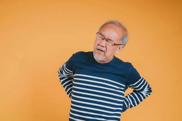 stock image Asian senior man feeling backache or back pain on the yellow background.