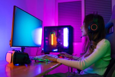 Asyalı bir kadının çevrimiçi video oyunu oynadığı oyuncu ve E-Sport çevrimiçi ışıklandırma efektiyle, evinde canlı yayın yapıyor. Oyuncu ve E-Sport çevrimiçi oyun teknolojisi şampiyonluğu turnuvası.