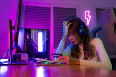 Kredi kartı konseptiyle çevrimiçi bir oyun. Asyalı bir kadının çevrimiçi video oyunu oynadığı oyuncu ve E-Sport çevrimiçi ışıklandırma efektiyle, evinde canlı yayın yapıyor. Oyuncu ve E-Spor Oyunları