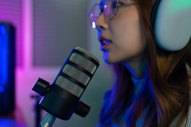 Asyalı bir kadının çevrimiçi video oyunu oynadığı oyuncu ve E-Sport çevrimiçi ışıklandırma efektiyle, evinde canlı yayın yapıyor. Oyuncu ve E-Sport çevrimiçi oyun teknolojisi şampiyonluğu turnuvası.