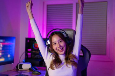 Online video oyunu oynayan Asyalı oyuncu PC 'de ışıklandırma efektiyle heyecanlanıyor, evde canlı yayın yapıyor. Oyuncu ve E-Sport çevrimiçi oyun teknolojisi şampiyonluk turnuvası oyuncu konsepti.