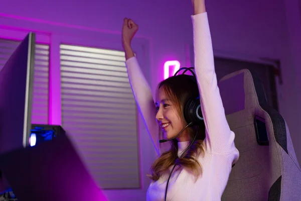 stock image Asian gamer playing online video game winning excited on PC with lighting effect, broadcast streaming live at home. Gamer and E-Sport online gaming technology Championship tournament gamer concept.