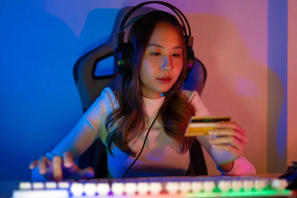 stock image Top up online game with credit card concept. Gamer and E-Sport online of Asian woman playing online computer video game with lighting effect, broadcast streaming live at home. Gamer and E-Sport gaming