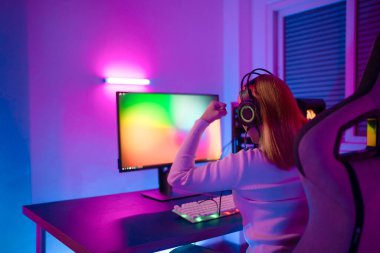 Profesyonel bir bayan profesyonel oyuncu çevrimiçi video oyunları siber spor ve esport şampiyonu duygusu oynar. Turnuvadaki genç kadın dünya çapında renkli neon ışıklarda maç yapıyor..
