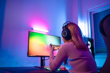 Profesyonel bir bayan profesyonel oyuncu çevrimiçi mobil oyunlar oynar siber spor ve esport şampiyonu duygusu. Turnuvadaki genç kadın dünya çapında renkli neon ışıklarda maç yapıyor..