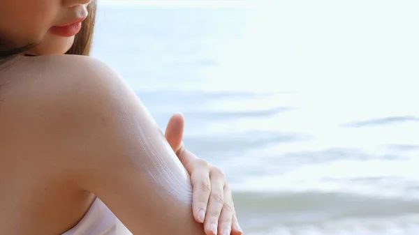 閉じるアップ笑顔若いアジア人女性を適用日焼け止めローション肩の上に彼女の肌で海辺のビーチトロピカル休息とリラクゼーション旅行ライフスタイル — ストック写真