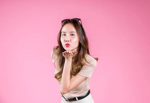 Kissing of asian young woman confident lipstick palm concept on the pink background