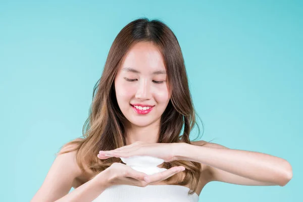 脸上的泡沫洗涤剂洗净和擦拭 快乐迷人的年轻亚洲女人在蓝色的背景上申请她的脸 — 图库照片
