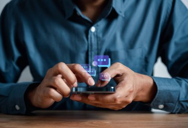 İş adamı iletişim ve sosyal ağ bağlantısına çevrimiçi teknoloji kavramına mesaj göndermek için akıllı telefon sohbetini kullanıyor.