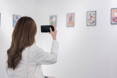 Sanat galerisini ziyaret eden bir kadın duvardaki resimleri sanat müzesindeki resim çerçevesi insan yaşam tarzı kavramını izliyor..