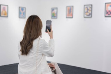 Sanat galerisini ziyaret eden bir kadın duvardaki resimleri sanat müzesindeki resim çerçevesi insan yaşam tarzı kavramını izliyor..