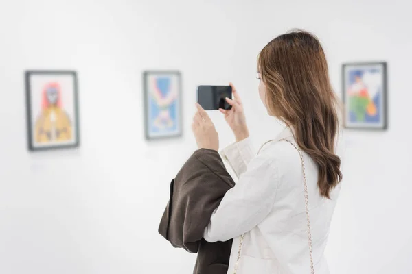 stock image Woman visiting art gallery her looking pictures on wall watching photo frame painting at artwork museum people lifestyle concept.