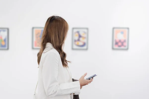 stock image Woman visiting art gallery her looking pictures on wall watching photo frame painting at artwork museum people lifestyle concept.