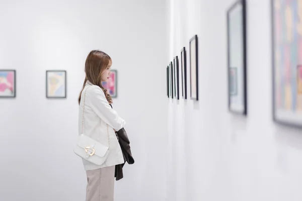 stock image Woman visiting art gallery her looking pictures on wall watching photo frame painting at artwork museum people lifestyle concept.