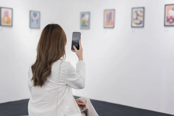stock image Woman visiting art gallery her looking pictures on wall watching photo frame painting at artwork museum people lifestyle concept.