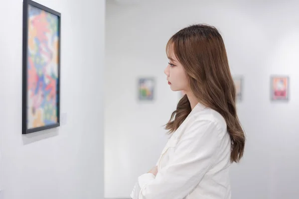 参观美术馆的妇女在墙上看照片 在美术馆里看相框画的人的生活方式观念 — 图库照片